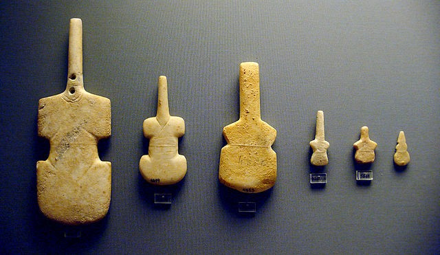 Six brown stone violin shapes of varying sizes
